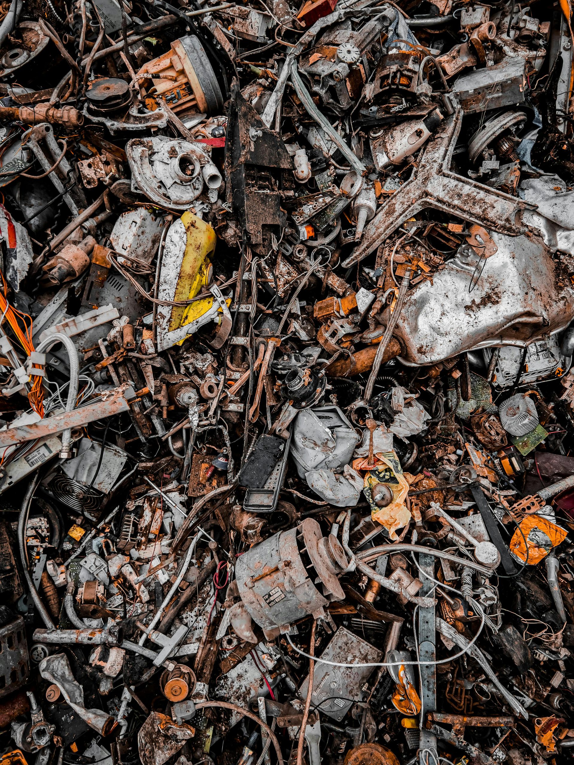 A chaotic pile of metal scrap and waste, showcasing decaying and rusty components in an industrial setting.